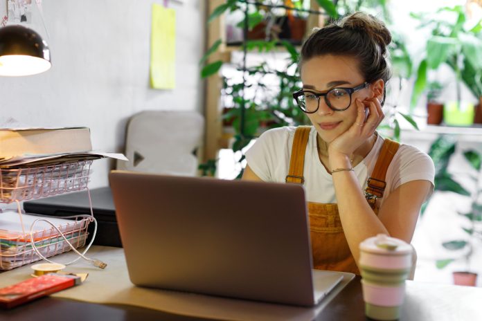 Young woman in glasses using a laptop