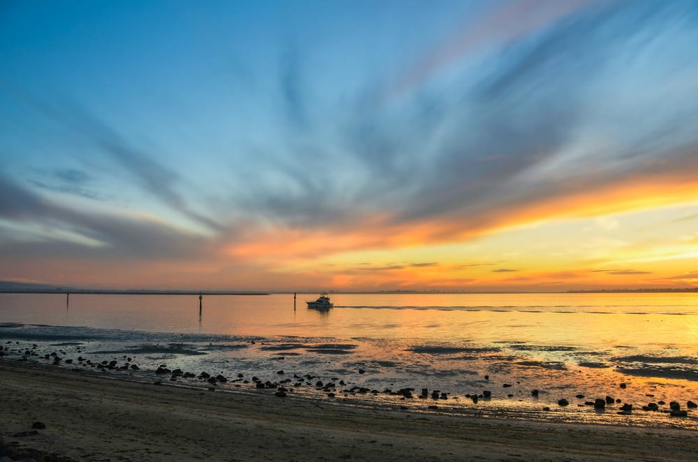 San Diego Bay and the silhouette of a sports fishing boat as seen from Chula Vista Bayside Park